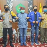 Bupati Pamekasan, Kapolres, dan para aktivis PMII bergandengan tangan usai menyepakati komitmen perdamaian. 