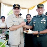 Wabup Pungkasiadi dan Danrem 082/CPYJ Kolonel Arm Budi Suwanto, saat panen padi di lokasi pembuatan model di Dusun Karangbendo, Desa Sumberjati, Kecamatan Mojoanyar. Foto: YUDI EP/BANGSAONLINE