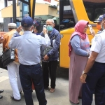 Begitu datang, satu per satu penumpang langsung dilakukan pemeriksaan suhu tubuh menggunakan alat thermo gun.