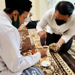 Santri Prof. Dr. KH. Asep Saifuddin Chalim, M.A., meneteskan madu kepada Ustad Karno, salah seorang peserta salat malam di kediaman Ning Imah di lingkungan Pondok Pesantren Amanatul Ummah Surabaya tadi malam, Kamis (15/7/2021). foto: mma/ bangsaonline.com