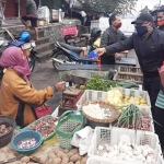 Kadiskopumdag Kota Batu, Drs. Suhartono saat memberikan masker kepada PKL sayur, Minggu (26/4).