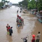 Warga berusaha menerobos banjir yang menggenangi Jalan Pantura Kraton, Pasuruan, Jawa Timur, Kamis (30/6). ANTARA FOTO/Umarul Faruq