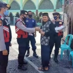 Anggota Satsabhara Polres Batu saat memberikan masker kepada salah seorang jamaah  salat Jumat di Masjid An-Nur Kota Batu, Jumat (3/7).