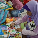 Salah satu anak berkebutuhan khusus saat lomba mewarnai. foto: SYUHUD/ BANGSAONLINE