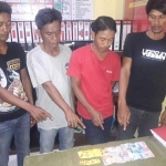 Para tersangka sedang menunjukkan barang bukti berupa satu set kartu domino saat di Polsek Sidayu.