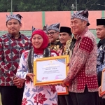 Gubernur Jatim, Khofifah Indar Parawansa saat menyerahkan piagam penghargaan kepada Wabup Tuban, Joko Sarwono yang hadir mewakili Bupati  Halindra