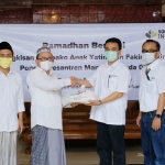 General Manager SBI Pabrik Tuban, Erwin H. Purba menyerahkan santunan kepada Pengasuh Ponpes Mansyaul Huda 02 Senori, Kiai Agus Ali As