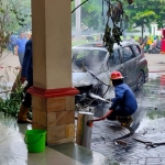 Petugas PMK Pemkab Sidoarjo sedang memadamkan sisa-sisa api.