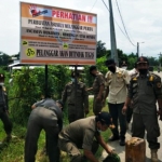 Petugas Satpol PP Kabupaten Mojokerto ketika menyegel dan memasang banner larangan praktek prostitusi di lokasi.