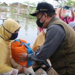 Bupati Fadeli saat  memberikan bantuan kepada warga korban banjir.