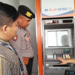 Petugas saat melakukan pengecekan di salah satu ATM.