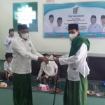 H. Syafiuddin, S.Sos, Ketua DPC PKB Bangkalan saat menyerahkan potongan tumpeng kepada KH. Makki Nasir, Ketua PCNU Bangkalan, di Gedung PKB Bangkalan, Kamis (16/9/2021).