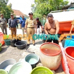 Camat Duduksampeyan, Merista Dedy Hartadi, saat memantau bantuan air bersih di desa-desa yang mengalami krisis air bersih. Foto: SYUHUD/BANGSAONLINE