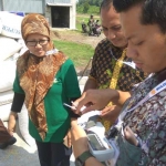 Petugas Bulog Divre Kediri saat mengecek kadar air milik petani di desa Mekikis, Kecamatan Purwoasri, Kediri.