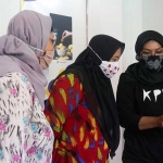 Kru Kelas Pagi Kediri (KPK) saat menjelaskan kepada pengunjung pameran foto produk. (foto: ist.)