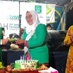 Ketua GP Ansor Kabupaten Mojokerto, Gus Barra, saat menyerahkan potongan tumpeng kepada Ketua Fatayat NU didampingi Ketua DPRD Kabupaten Mojokerto, Ayni Zuroh.