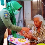 Penyaluran bantuan telur oleh salah satu pegawai Dinas Pertanian pada warga miskin di Kelurahan Sumbergedong.
