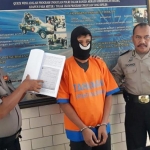 Khoirul sedang diapit petugas Polsek Krian, Sidoarjo.