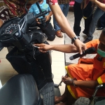Tersangka yang duduk di kursi roda saat menunjukkan bagaimana aksinya dilancarkan. (foto: TRIWIYOGA/ BANGSAONLINE)
