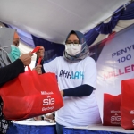 Penyerahan bantuan paket sembako oleh milenial SIG kepada warga sekitar Pabrik Gresik, Jawa Timur. Foto: Ist