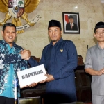 Ketua DPRD Kota Kediri Kholifi Yunon saat menyerahkan Perda yang telah disetujui DPRD kepada Walikota Kediri Abdullah Abu Bakar. Foto: ARIF K/BANGSAONLINE