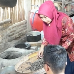Seorang Ibu sedang membuat krecek mangga podang. 