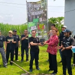 Yuwono (kanan), seorang penggiat herbal dan lingkungan di Kediri secara simbolis menyerahkan bibit pohon Joho kepada Kepala Desa Joho, Setyo Wibowo untuk ditanam bersama-sama. Foto: Muji Harjita/Bangsaonline.