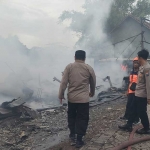 Petugas saat meninjau gudang pakan ternak yang ludes terbakar di Sidoarjo.