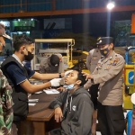 Suasana saat Tim Pamor Keris Polres Mojokerto Kota melakukan swab antigen acak kepada pengunjung warung kopi.