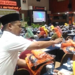 Seorang panitia menarik kembali kaos paslon milik SAE, nomor urut 3, saat beredar di acara wawasan kebangsaan Bakesbangpol Jatim, di Hotel Aria Gajayana Malang, Selasa (10/4). Foto: IWAN I/BANGSAONLINE