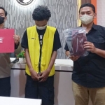 Tersangka tertunduk lesu saat diapit anggota Polrestabes Surabaya.