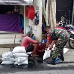 Babinsa Kelurahan Kandangan, Koramil 0830/06 Benowo, Sertu Supri, dan Serda Eby, saat membersihkan saluran air guna mencegah banjir serta memberantas sarang nyamuk.