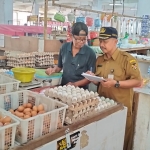 Petugas saat melakukan pemantauan harian terhadap harga komoditas pangan di pasar Setono Betek. (Ist).
