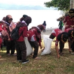 Para Siswa MTsN 1 Trenggalek saat bersih-bersih sampah di Pantai Mutiara. foto: HERMAN/ BANGSAONLINE