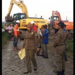 Petugas Dispol PP Gresik saat menghentikan pemasangan pipa Pertamina Gas di Desa Kedanyang Kebomas. foto: SYUHUD/ BANGSAONLINE
