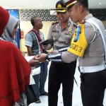 Kapolres Gresik AKBP Wahyu Sri Bintoro didampingi Kasat Lantas AKP Whika berbincang dengan pembuat SIM. foto: SYUHUD/ BANGSAONLINE