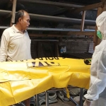 Petugas saat mengevakuasi jenazah pria yang ditemukan gantung diri dalam toko galangan di Desa Tropodo, Kecamatan Waru, Sidoarjo.