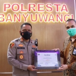 Kapolresta Banyuwangi, AKBP Nasrun Pasaribu, saat menerima penghargaan dari Kepala KPPN Banyuwangi, Biworo Hariwidjaya.