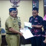 Bupati Rijanto menyerahkan dokumen Adminduk kepada warga yang mengurus Adminduk menggunakan E-SIAP.