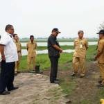 Penjabat Bupati Gresik, Akmal Boedianto saat melihat tanggul sungai Kali Lamong di Desa Jono Kc. Cerme. foto: syuhud/ BANGSAONLINE