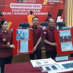 BUKTI: Terduga WN Cina dan barang bukti joki tes Bahasa Inggris saat dihadirkan dalam konferensi pers di Kantor Imigrasi Surabaya, Rabu (5/7/2023). foto: MUSTAIN/ BANGSAONLINE