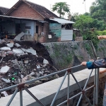 Dapur rumah Mbok Sura yang ambruk dilihat dari sisi seberang sungai.