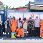 POSE BERSAMA: Tim BHS Peduli baksos penyemprotan disinfektan di Desa Jumputrejo, Sukodono, Selasa (6/7/2021). (foto: ist)