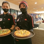 Pegawai Pizza Hut menunjukkan menu favorit.