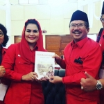 Bambang DH sat menyerahkan sebuah buku berjudul 