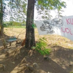 Sebuah poster membentang sebagai bentuk penolakan penggusuran makam.