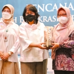 Wakil Bupati Gresik, Aminatun Habibah, ketika menerima penghargaan. Foto: SYUHUD/ BANGSAONLINE.com
