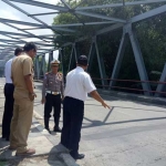 Petugas mengecek sambungan jembatan di desa Sawo kecamatan Karangjati. foto: ZAINAL/ BANGSAONLINE