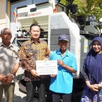 Bupati Yuhronur menyerahkan mesin combine harvester ke petani.