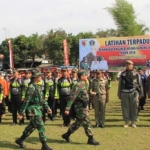 Danrem 081/DSJ Kolonel Inf Masduki sedang melakukan inspeksi pasukan.